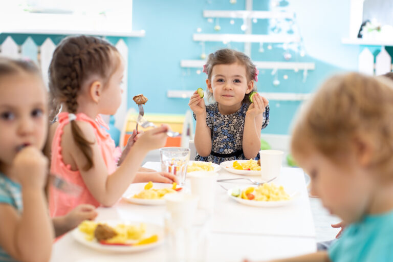 group of kids eating healthy food in preschool