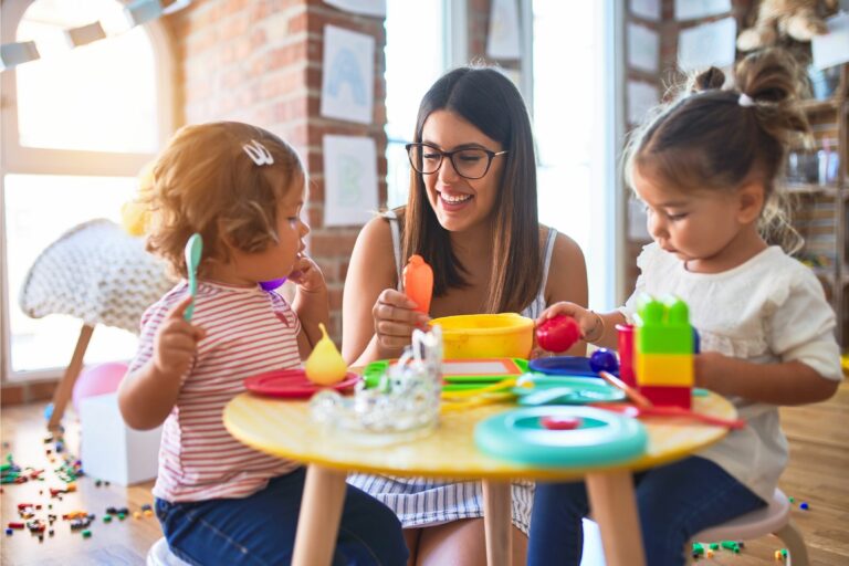 teacher and toddlers playing dinner party at daycare