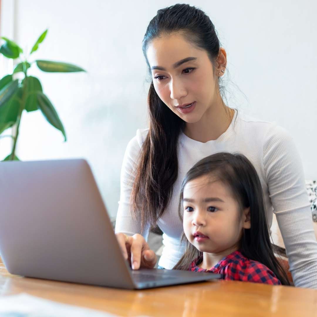 Mother with young daughter using a laptop