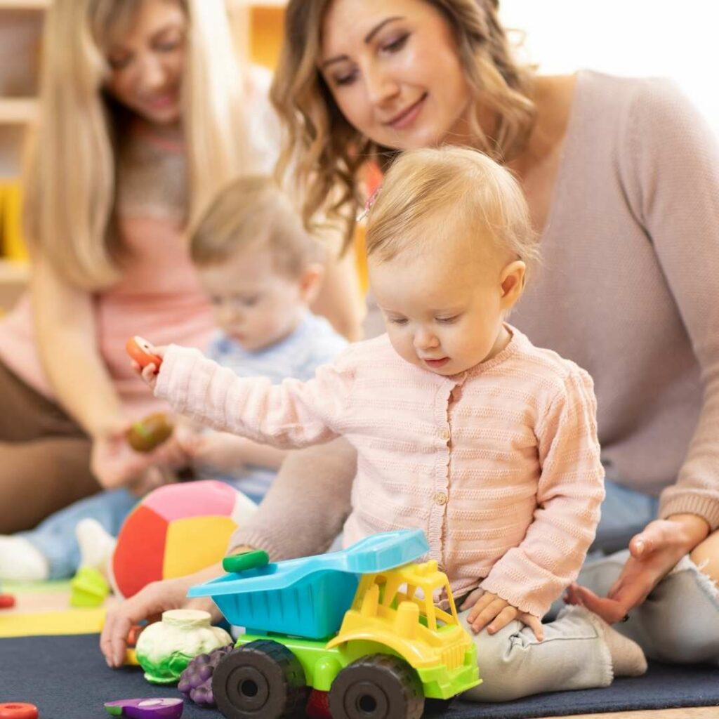 Women playing with toddlers