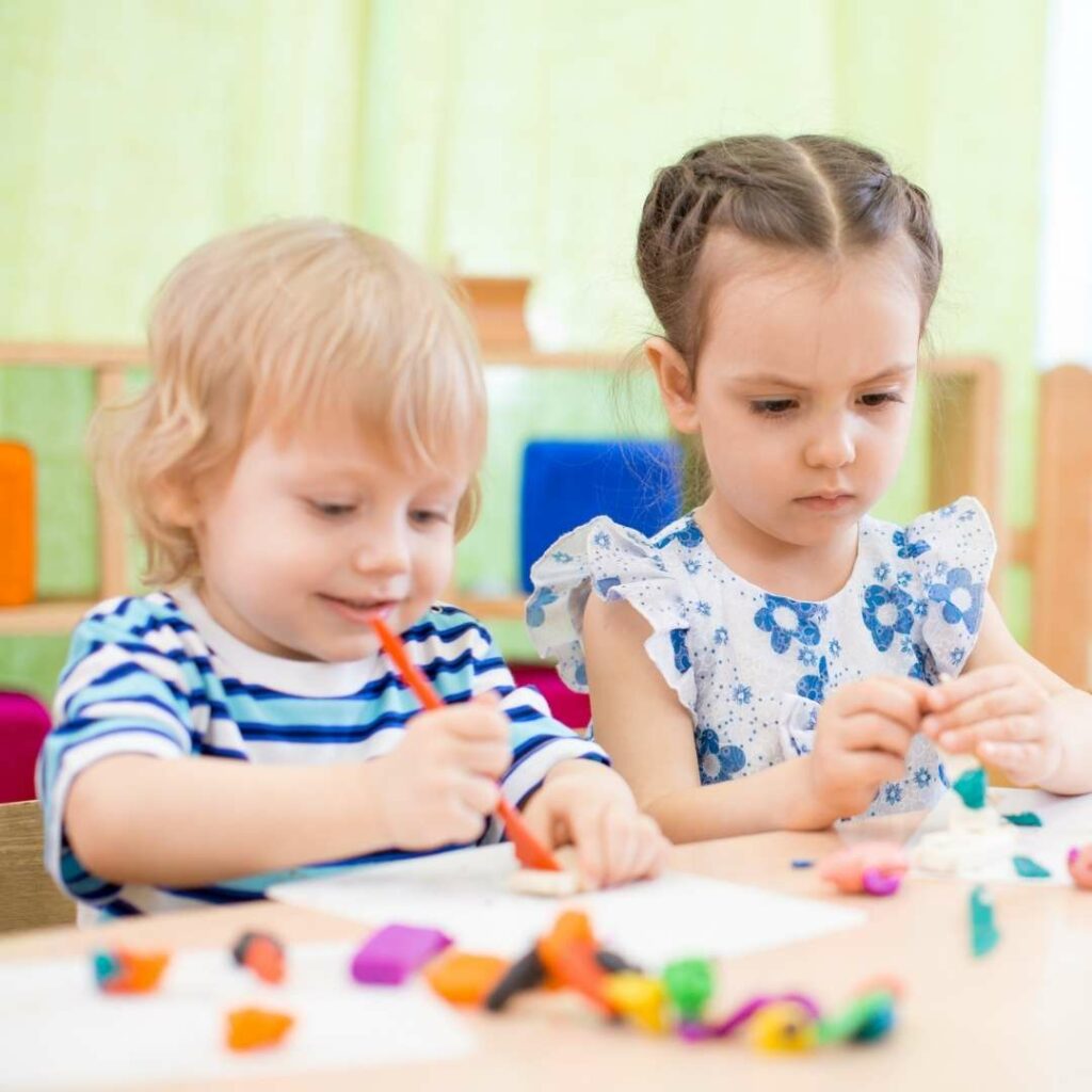 Two kids doing an art project at a table