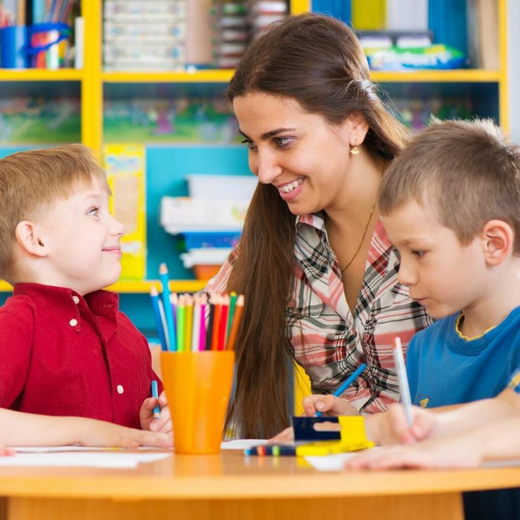 Woman with two children at a desk doing an art project