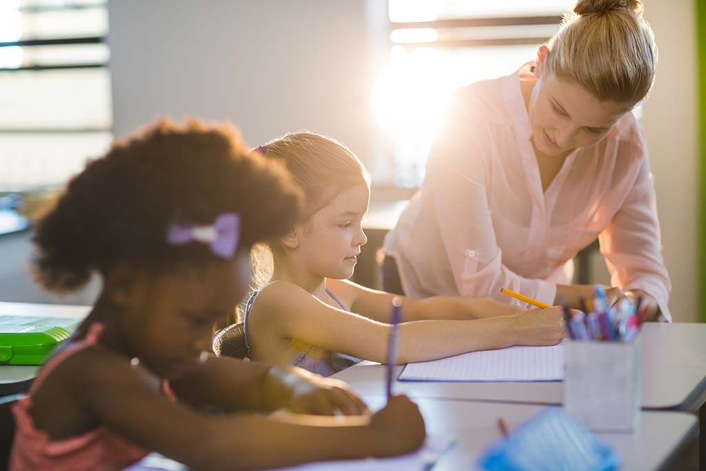 Teacher assisting children with a learning activity