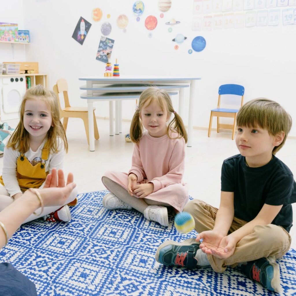 Three young children sitting in a semi-circle. 