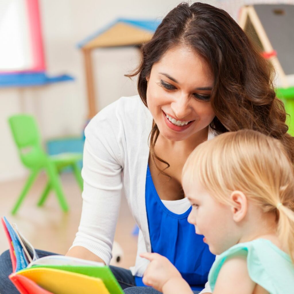 Female teacher working with a young girl.