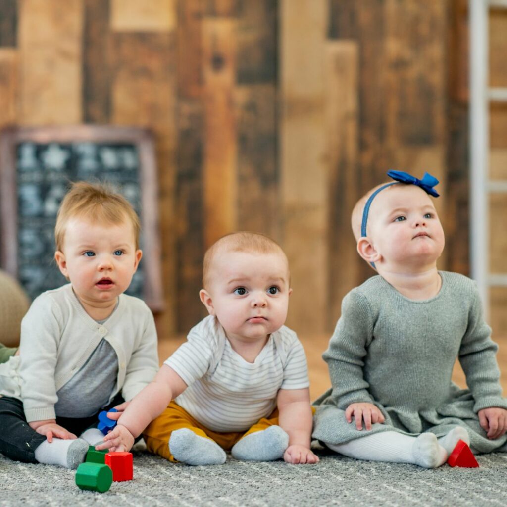 Three infants sitting next to each other.