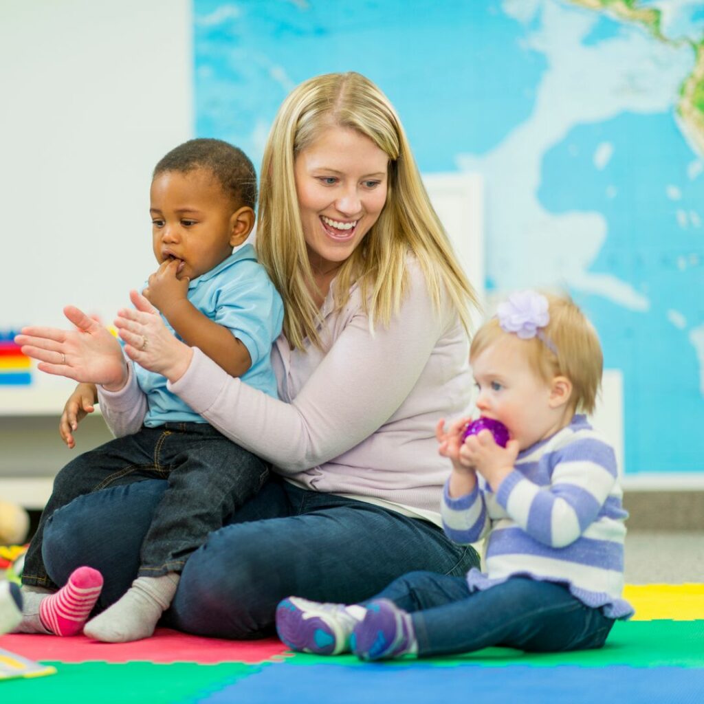Female teacher working with two young toddlers. 