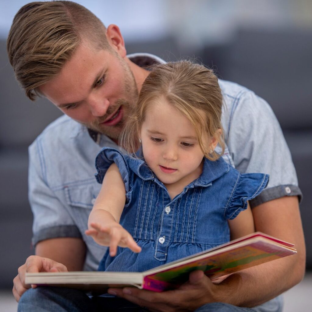 Father reading a book with his young daughter. 