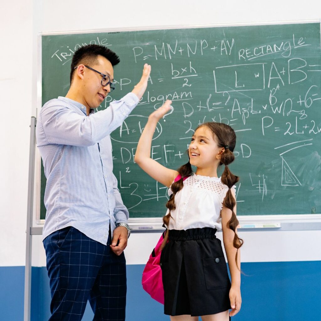 encouraging teacher high fiving kid